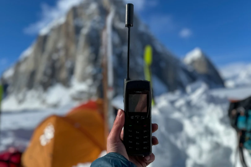 the author holds the iridium 9555 satellite phone in camp in alaska