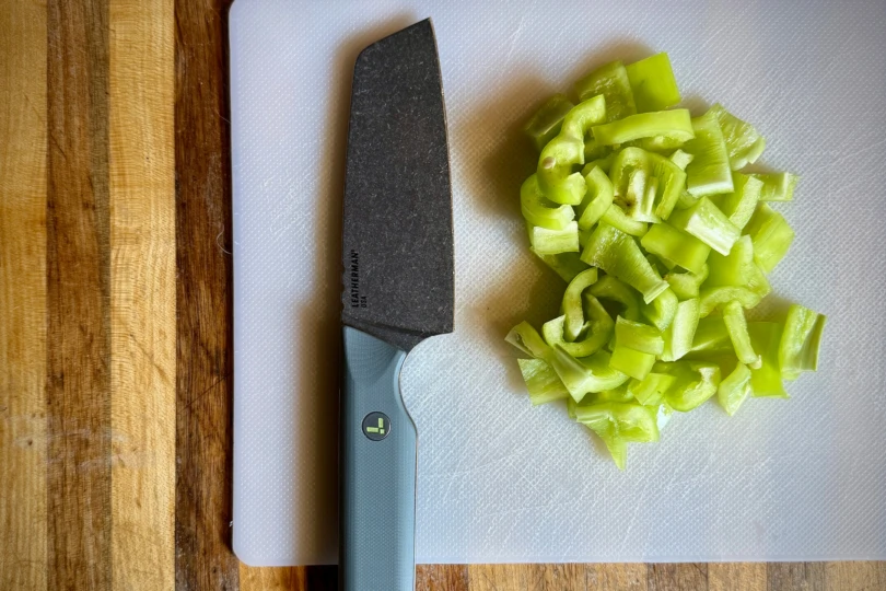 Leatherman Rustle next to freshly chopped green peppers on a white cutting board