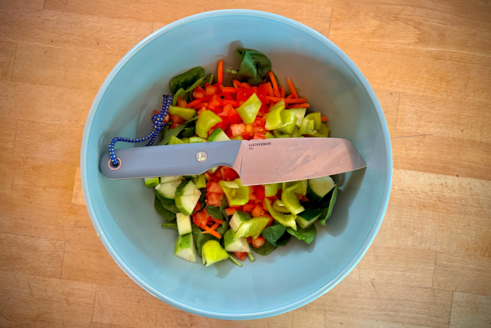 Leatherman Rustle rests across a bowl of chopped vegetables