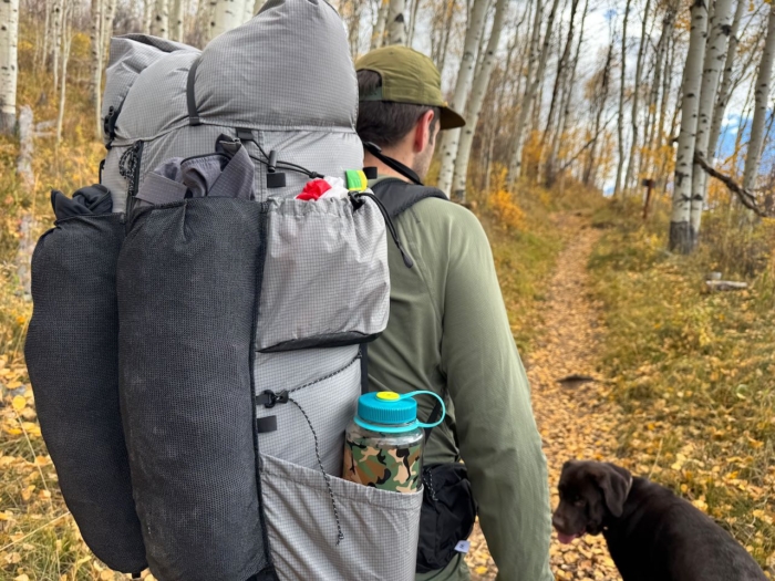 Close-up of the Outdoor Vitals Shadowlight 60 packed for a hike, showing gear pockets and side storage