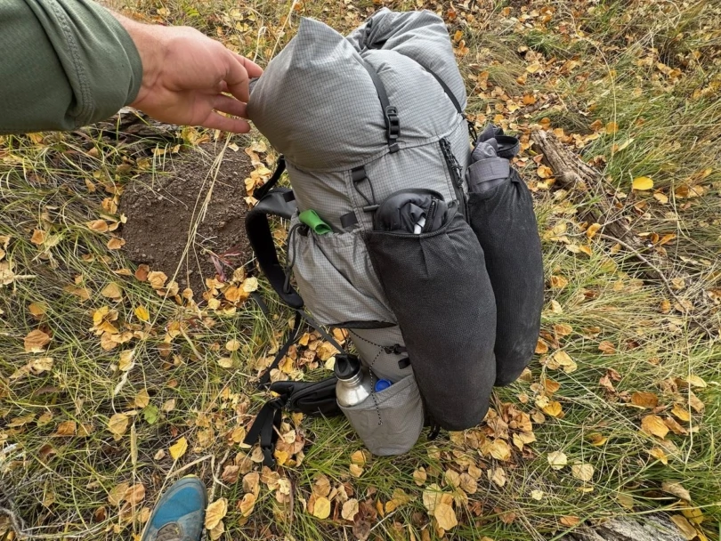 Outdoor Vitals Shadowlight 60 standing on the ground, showing its side storage and exterior mesh pockets