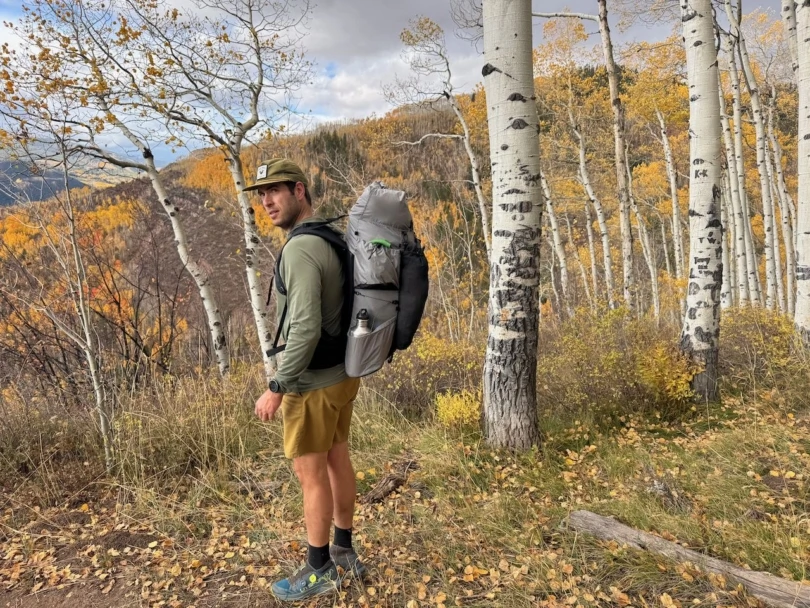 Outdoor Vitals Shadowlight 60 backpack worn on a mountain trail with fall colors in the background