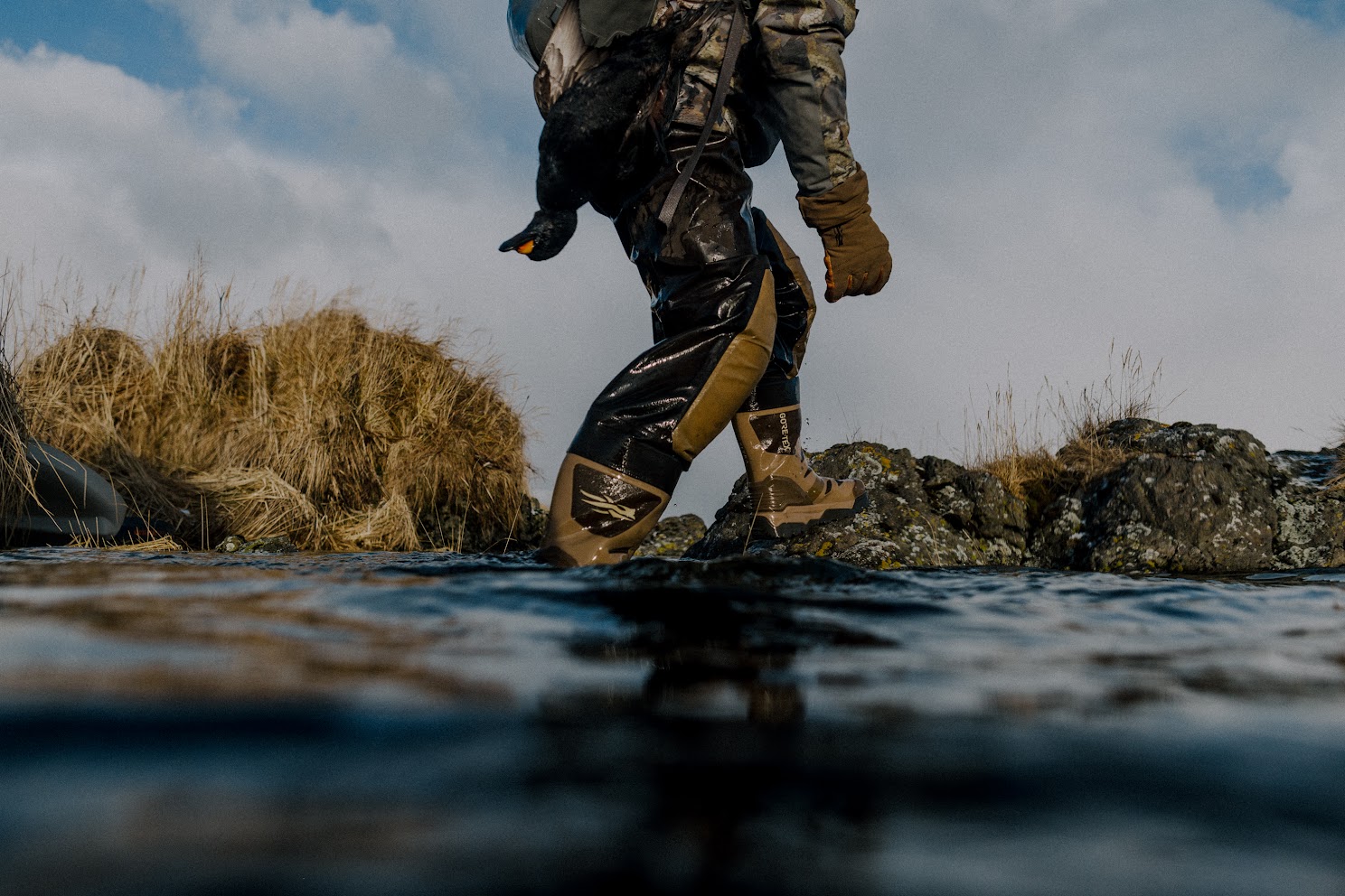 A hunter walking over rock in SITKA waders