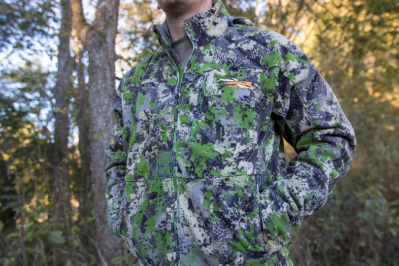 The SITKA Stratus 2.0 Jacket on a hunter in front of a wood line.