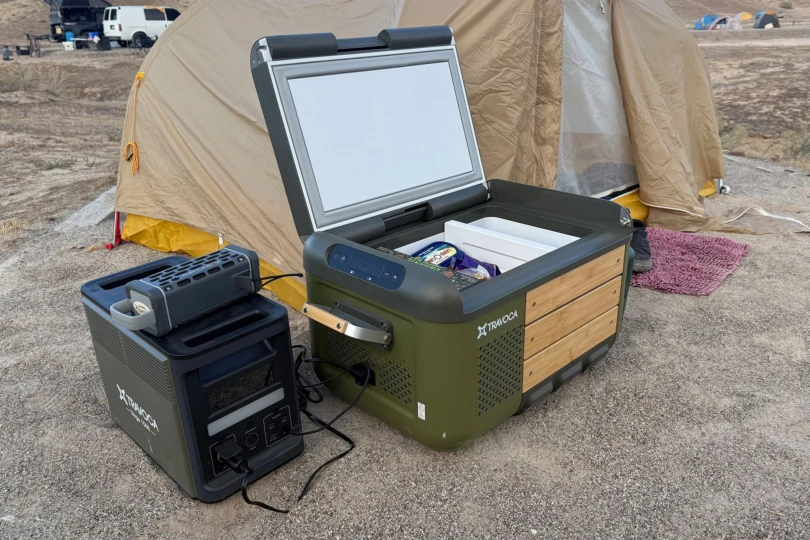 The TRAVOCA Rigel DZ eCooler and Vega 1500 power station set up beside a camping tent