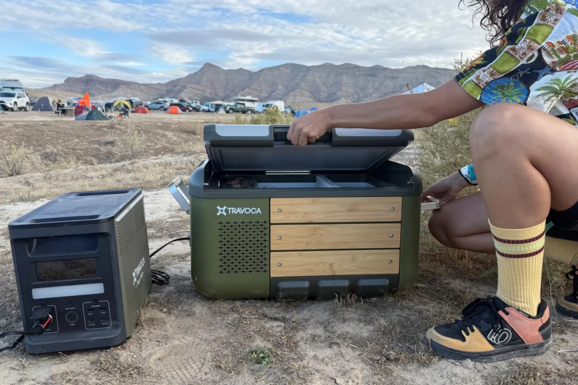 A camper opens the TRAVOCA Rigel DZ eCooler lid to access the cooled compartments
