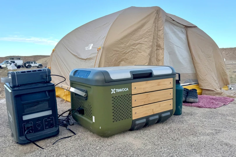 The TRAVOCA Rigel DZ eCooler and power station beside a tan tent during a camping trip