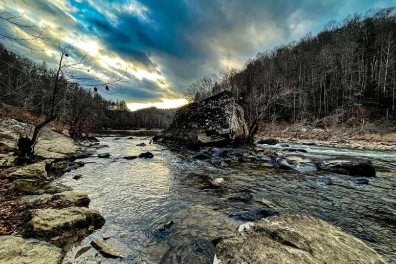 River bank with stormy sky and forests on each side