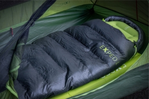 black and green sleeping bag set up in a tent