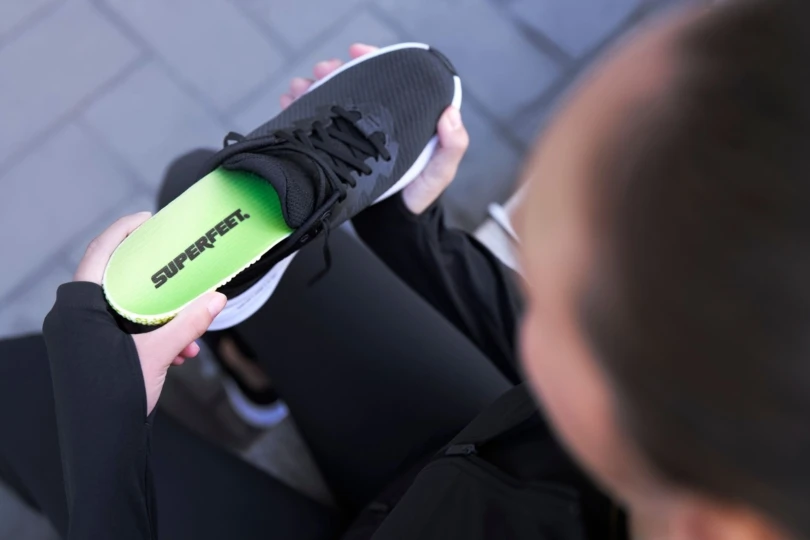 Person places insole into shoe