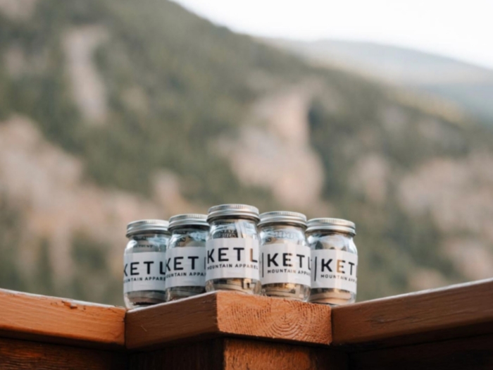 Group of jars with cash on table with mountains in background