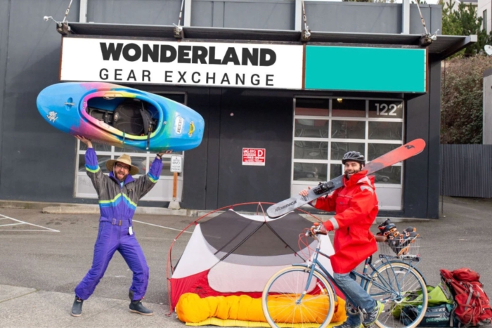 Two people with outdoor gear outside shop