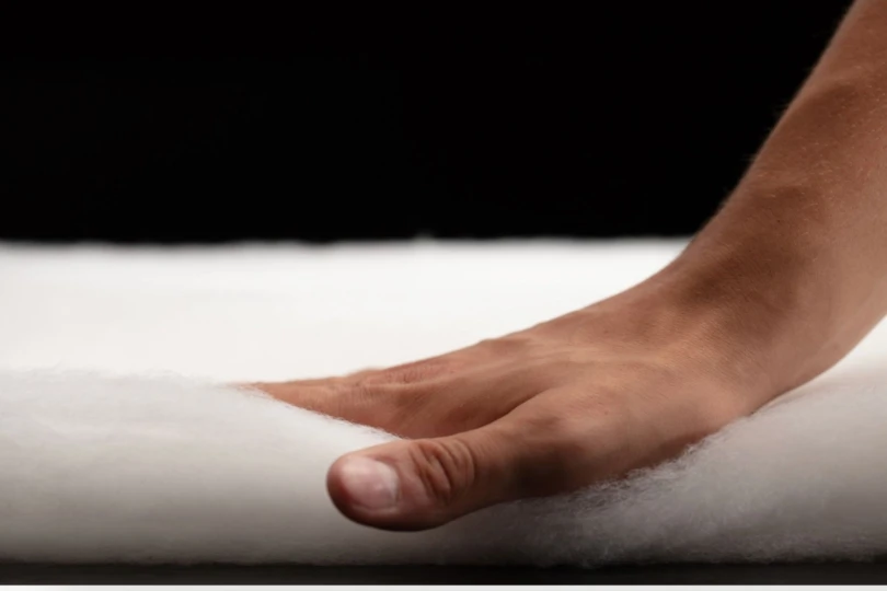 Hand presses down on insulation