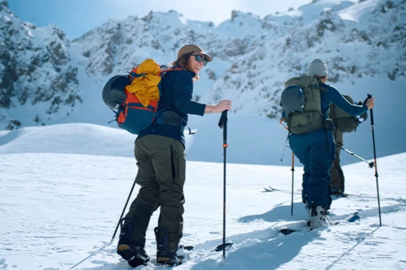 People hike up snowy mountain