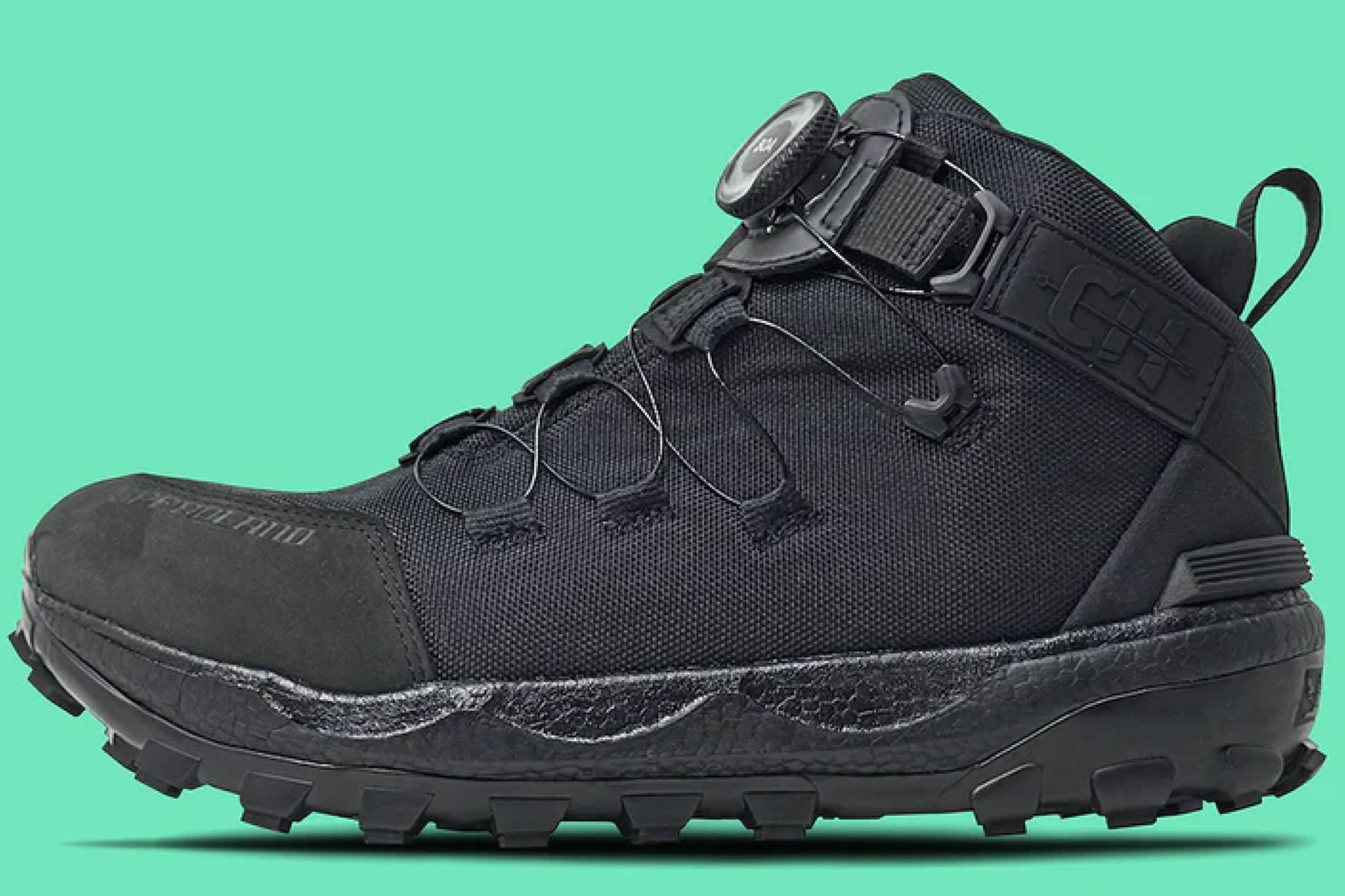 up-close shot of black hunting boot on green background