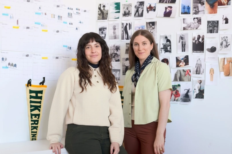 two women in front of wall with photos