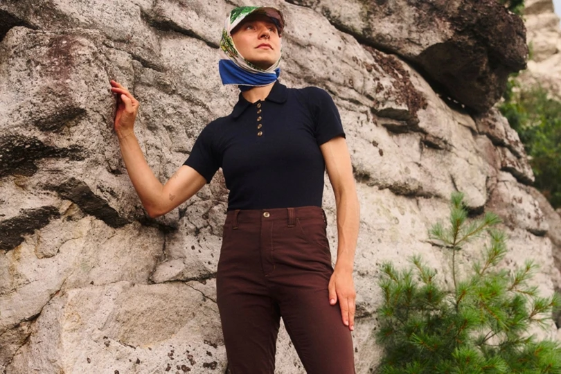 Woman stands next to rock outside
