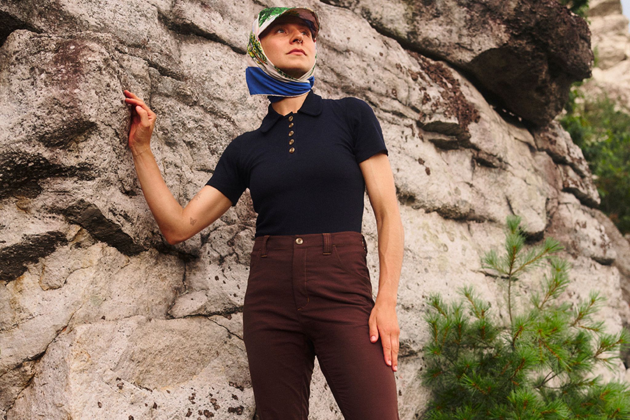 Woman stands next to rock outside