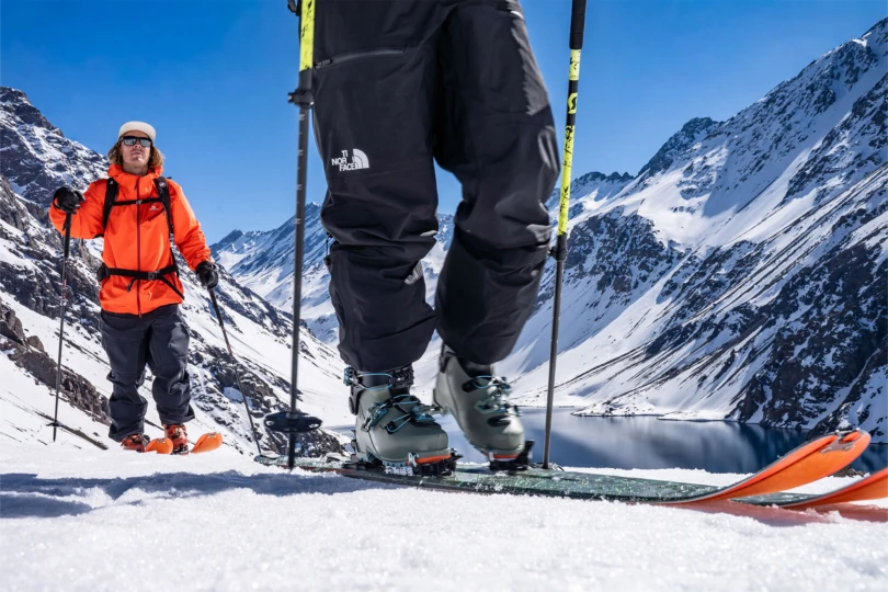 Two backcountry skiers climb a snowy slope with Blizzard Zero G 96 skis under clear mountain skies