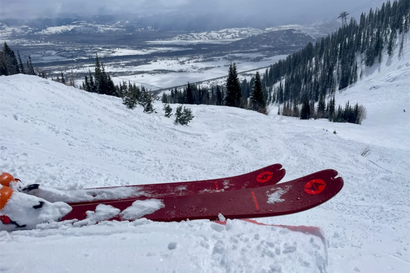 The Blizzard Zero G 96 skis rest on a snowy ridge overlooking a mountain valley