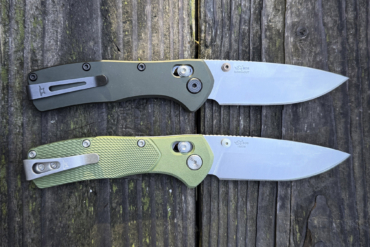 Two folding knives from the Buck Knives Range Series lying side by side on weathered wood, showing different handle textures and blade steels