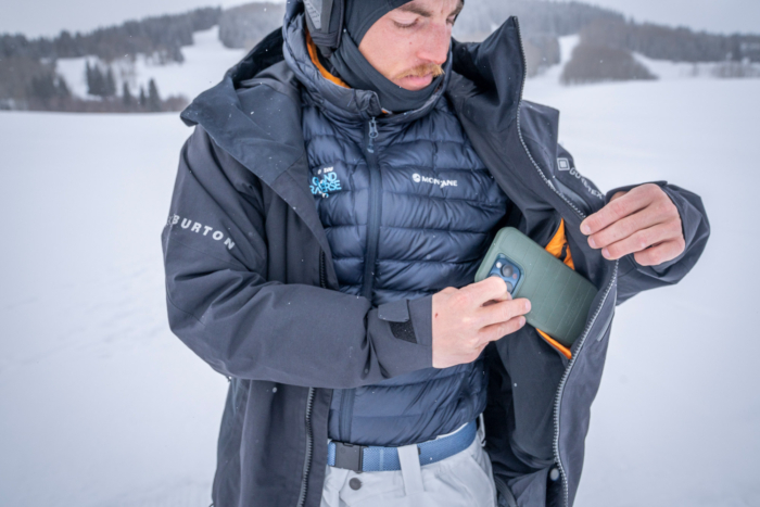 A rider opens the Cyclic Jacket to place a phone into the large interior pocket