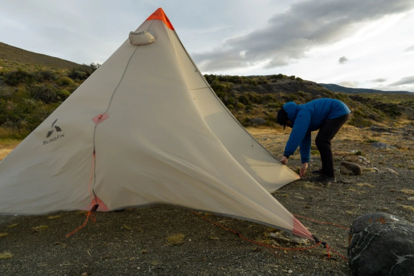 the author setting up a 4-season tent in 50 mph winds in patagonia