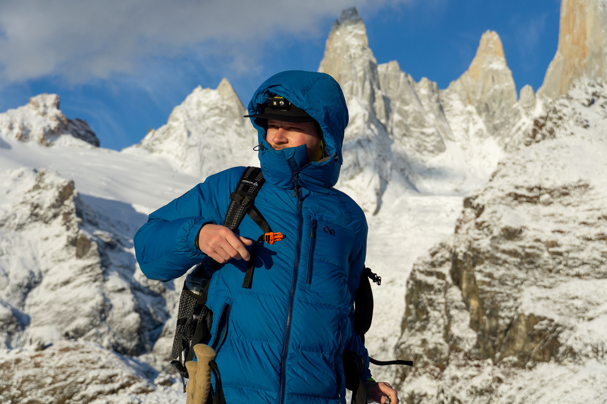 one of the authors in patagonia in front of snow-covered mountains and wearing a blue parka