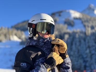 Woman wearing ski gloves with mountain in background