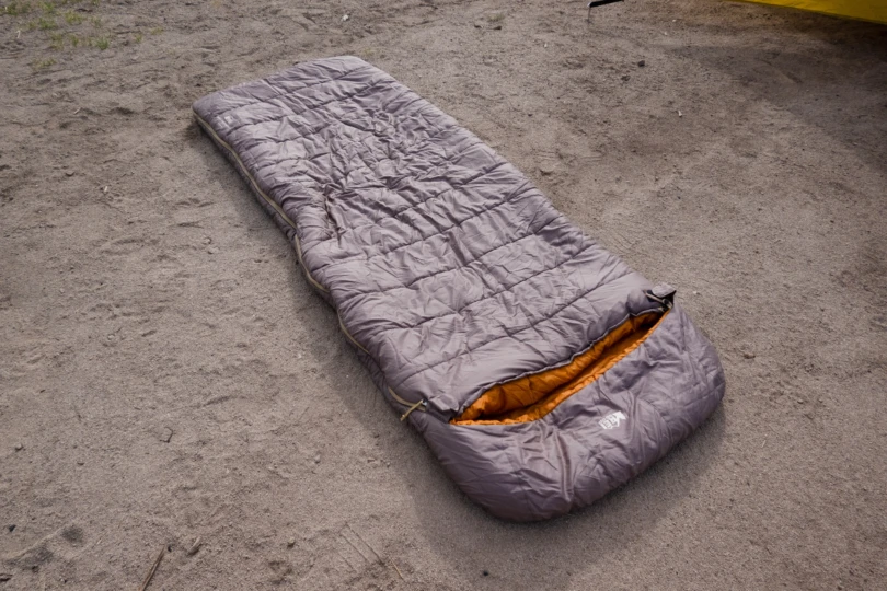 the rei siesta hooded sleeping bag laid on the ground