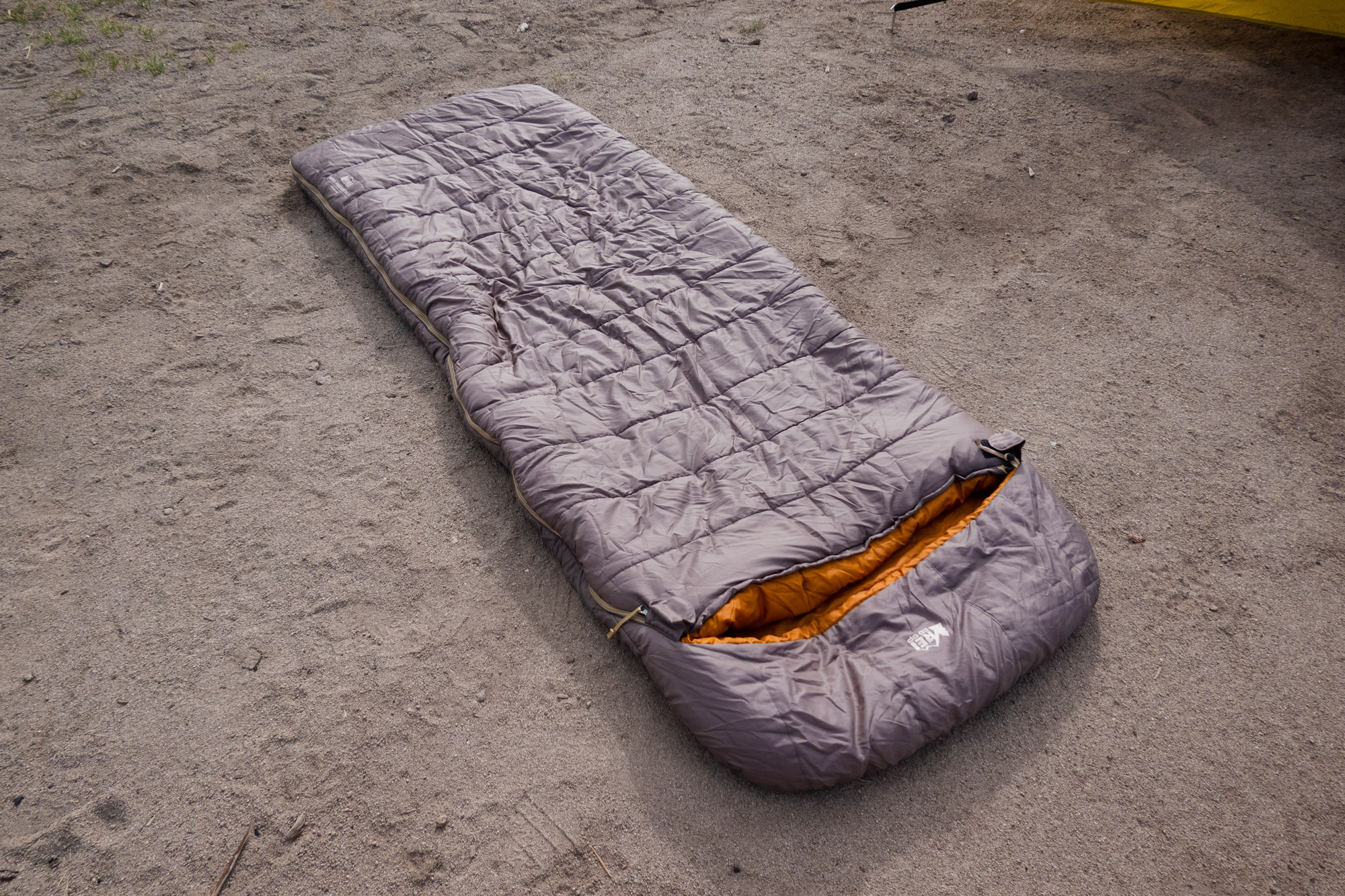 the rei siesta hooded sleeping bag laid on the ground
