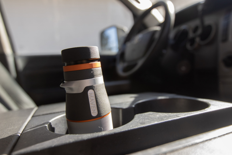 A monocular in a cupholder of a truck.