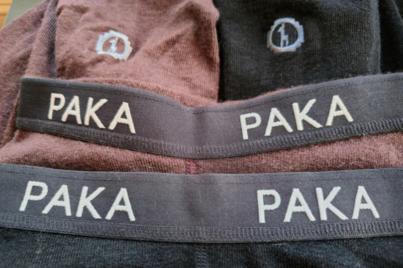 Two pairs of Paka Thermal Baselayer bottoms are laid flat, showing the thick PAKA waistband and the embroidered logo