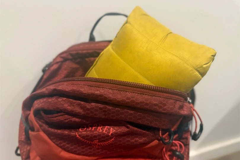 Yellow Rab Microlight Windstopper Hoody packed inside a red Osprey backpack