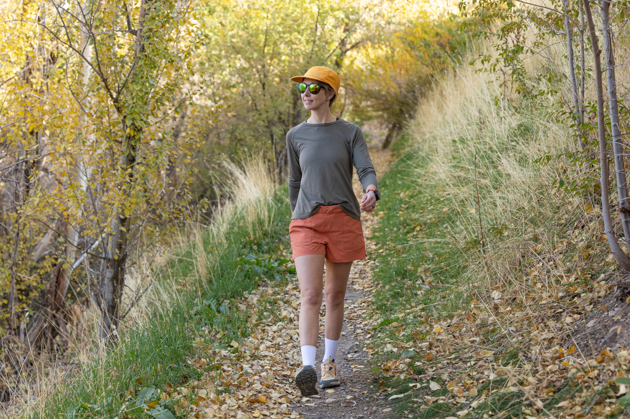 A person walking on a leafy trail wearing Rabbit High Country Shorts and hiking shoes
