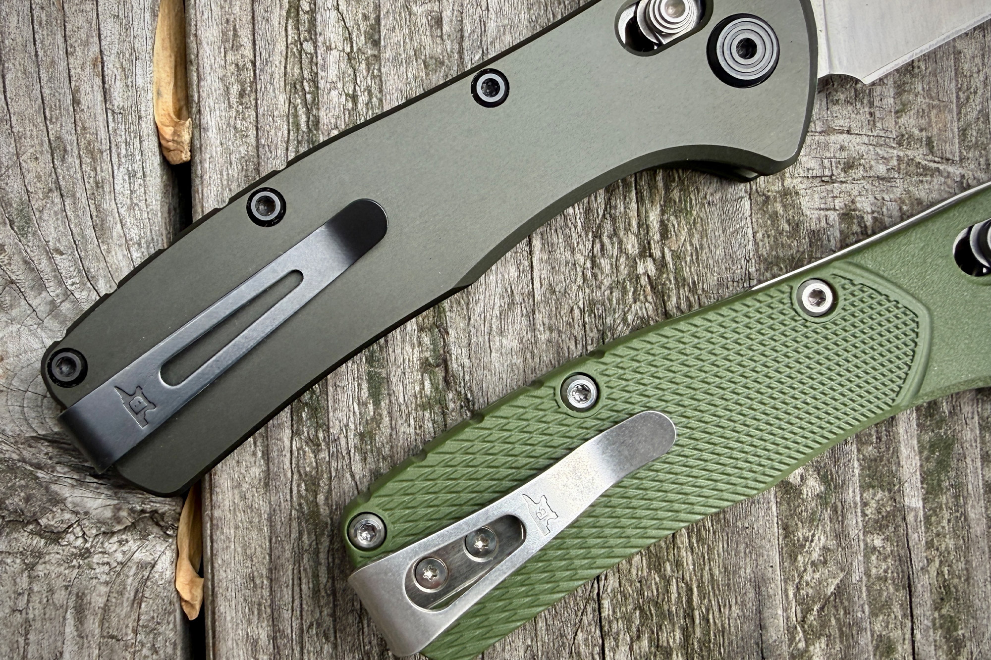A detailed look at two Range Pro pocket clips and textured handles set on aged gray wood