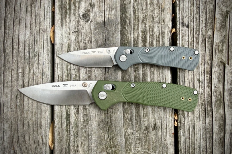 Two Range Pro knives in gray and green handles placed side by side on old wooden planks, blades open