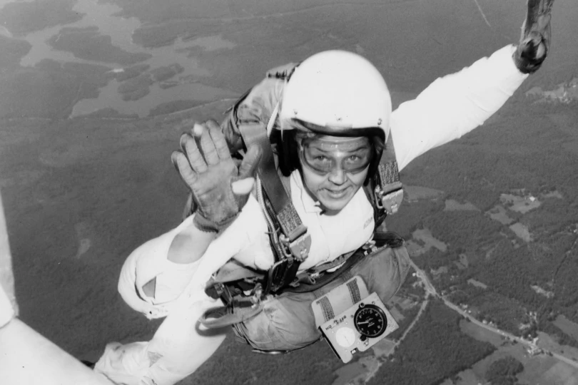 black and white photo of a women skydiving