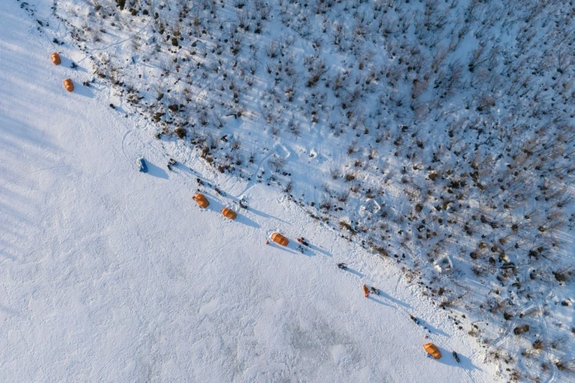 View from above of camp on snow with tents