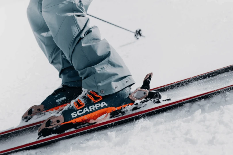 Close-up of person of ski boots as person skis down snow