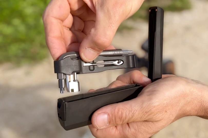 Close up shot of someone pulling a multitool out of a case