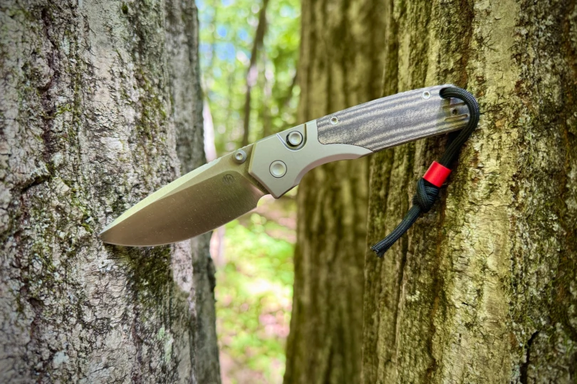 The Vosteed Psyop 299 wedged between two tree trunks outdoors