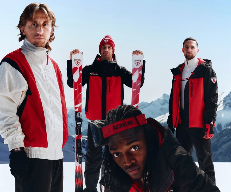 Group of four men wearing black, red, and white ski gear