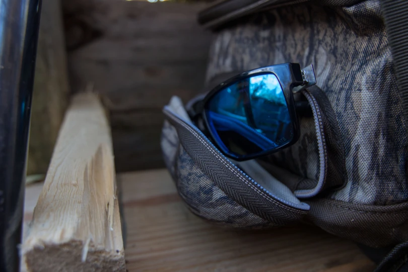 Sunglasses sticking out of the sunglasses holder on a bag.