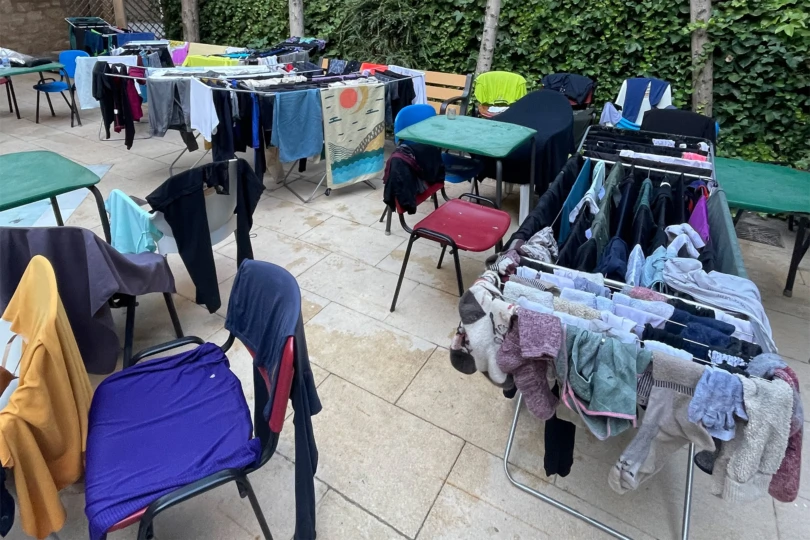 Clothes from pilgrims drying on racks and chairs after a long day on the Camino de Santiago hike