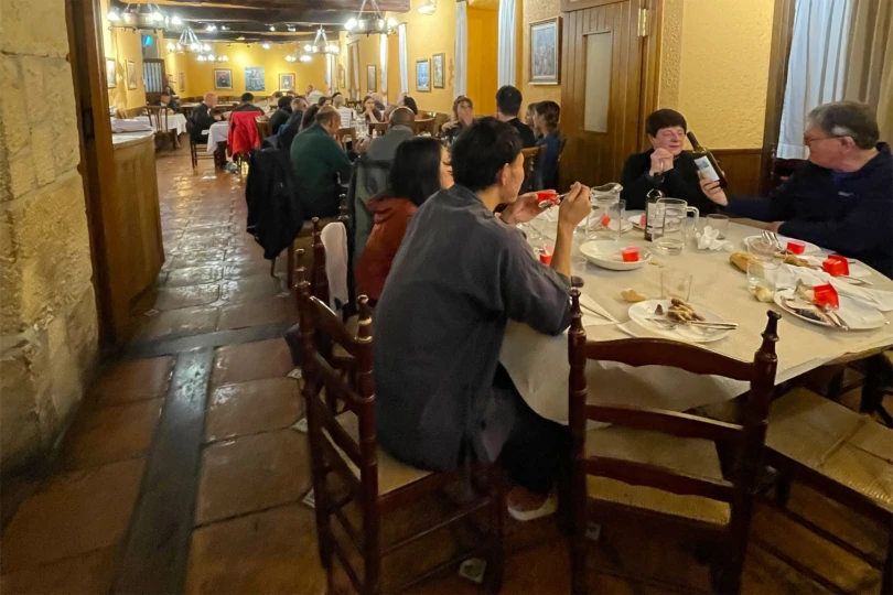 Pilgrims share a communal dinner in a busy dining room along the Camino route