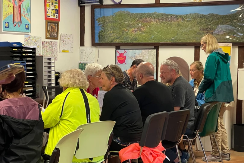 Pilgrims wait in a busy registration room to get information and stamps along the Camino route