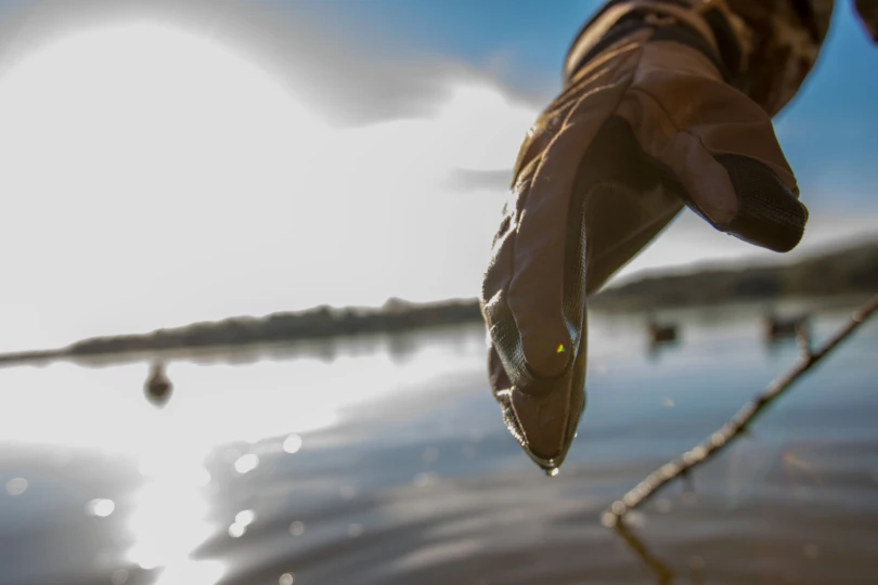 Water dripping from the Chêne Hydro-Lok Wool lined glove above a lakes surface.