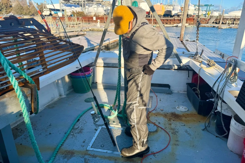 The Columbia PFG Force XII™ ODX Bib worn on a fishing boat, showing full-length coverage and fit