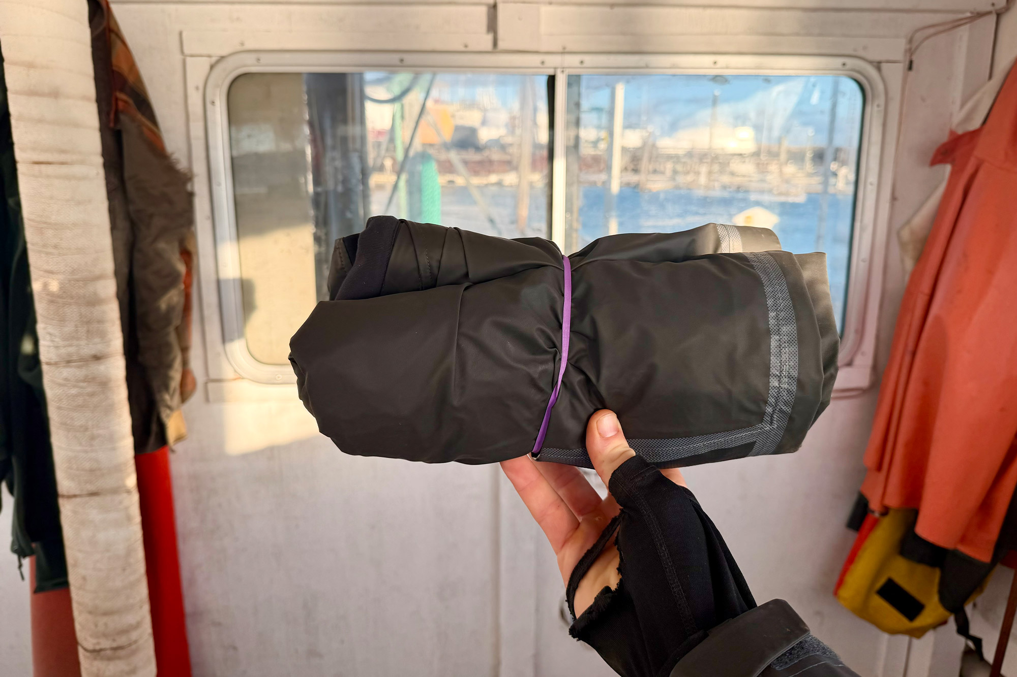 The Columbia PFG Force XII™ ODX Jacket rolled up and secured for compact storage onboard